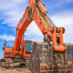 Equipment - Low Angle Photography of Orange Excavator Under White Clouds