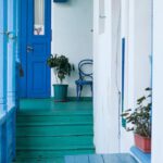 Community Growth - Balcony of residential building with blue wooden fence and potted plants on windowsill