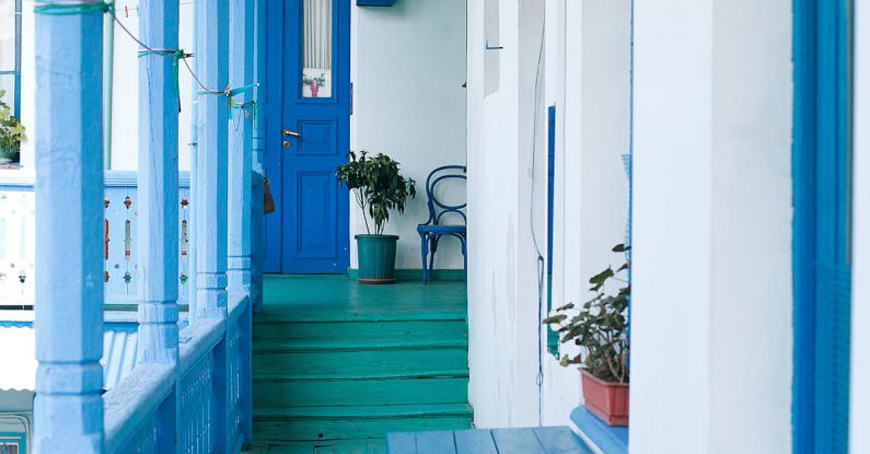 Community Growth - Balcony of residential building with blue wooden fence and potted plants on windowsill