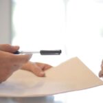 Customer Trust - Crop businessman giving contract to woman to sign