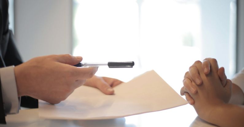 Customer Trust - Crop businessman giving contract to woman to sign