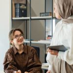 Aesthetic Planning - Two women in hijab talking in an office