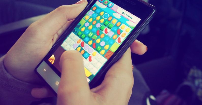 Mobile Games - Person Playing Candy Crush on Nokia Smartphone