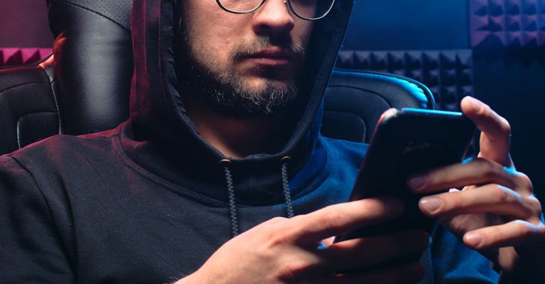 Phishing Attacks - A Man in Black Hoodie Sweater Using His Mobile Phone